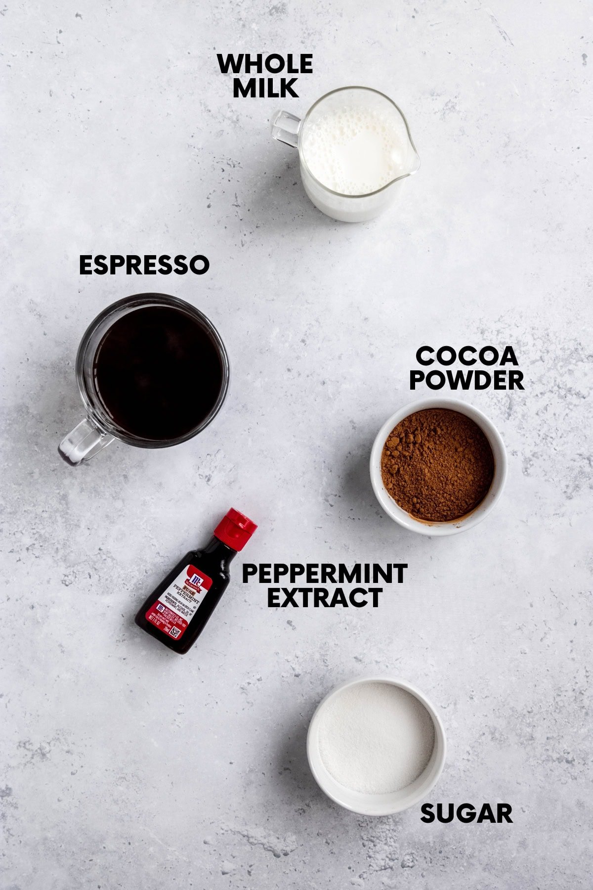 Ingredients for a peppermint mocha recipe: whole milk, espresso, cocoa powder, peppermint extract, sugar.