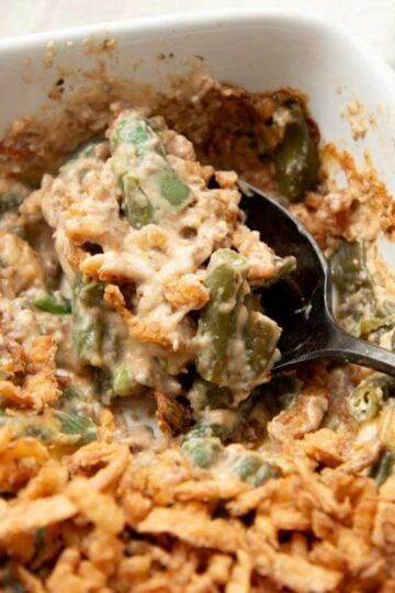 A spoon scoops up a serving of homemade green bean casserole.