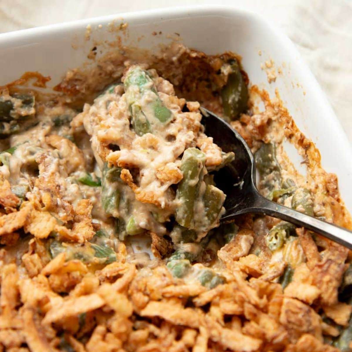 A spoon scoops up a serving of homemade green bean casserole.