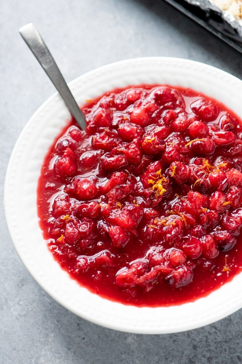 A bowl of cranberry orange sauce garnished with orange zest.