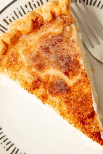 A slice of sugar cream pie with a broiled, browned top.