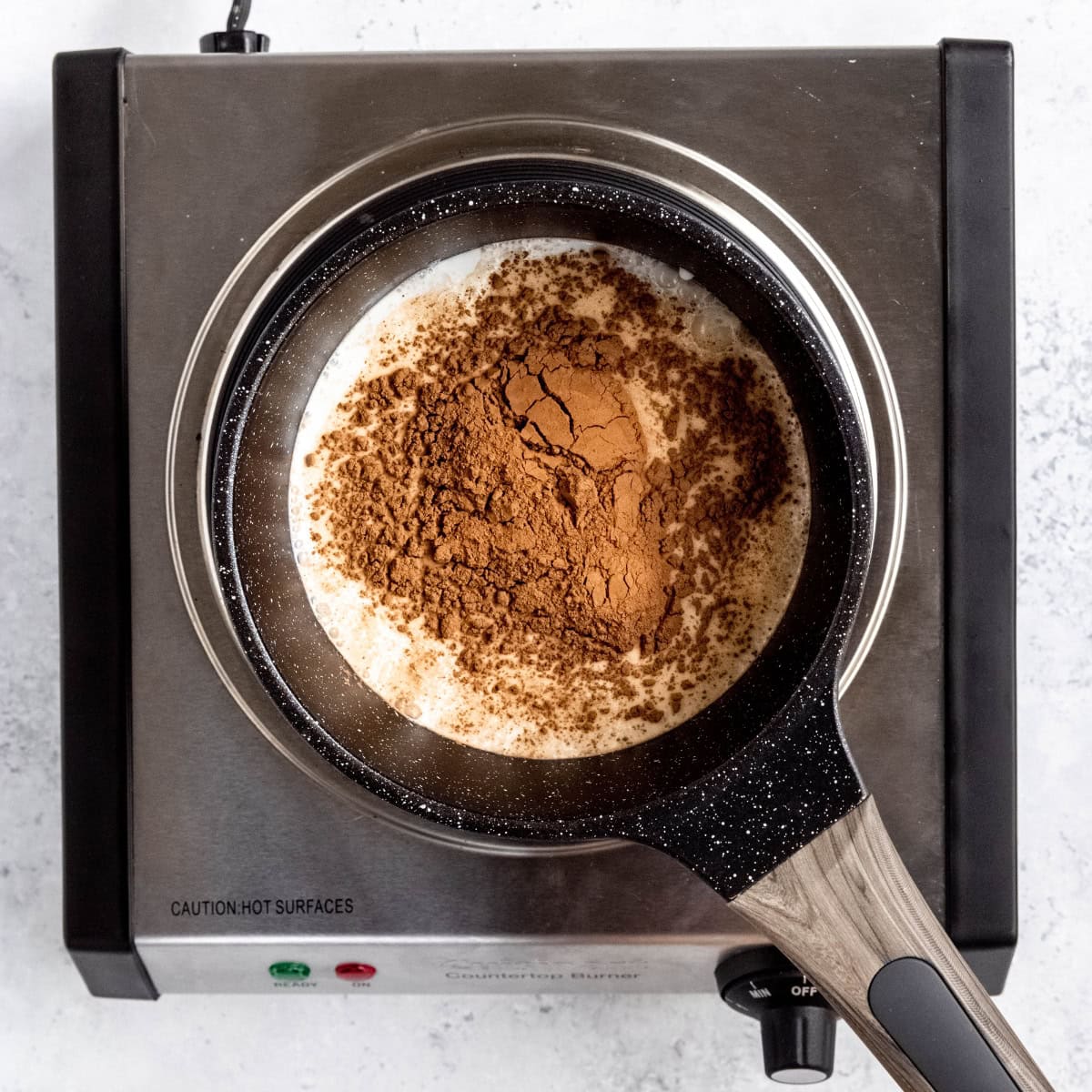 Ingredients for a peppermint mocha sauce in an enameled saucepan.