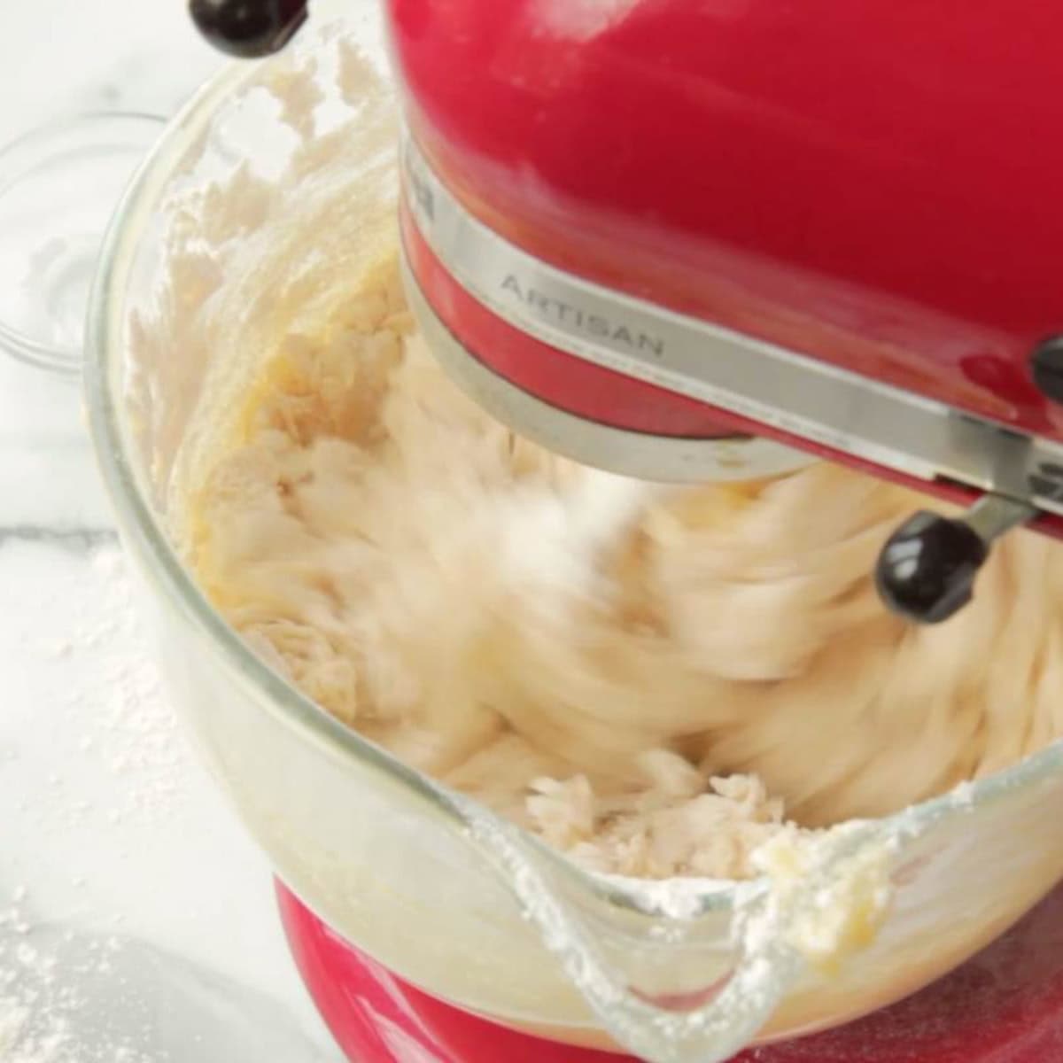 A red stand mixer makes sugar cookie dough.