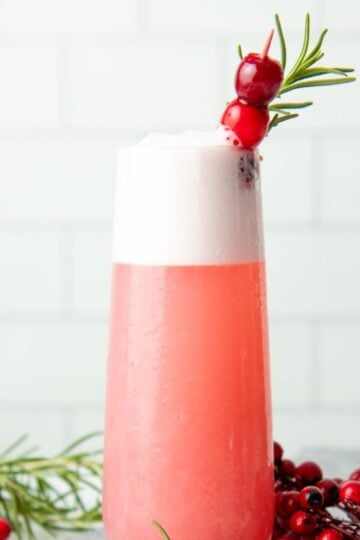 A cranberry gin fizz in a tall, narrow glass.