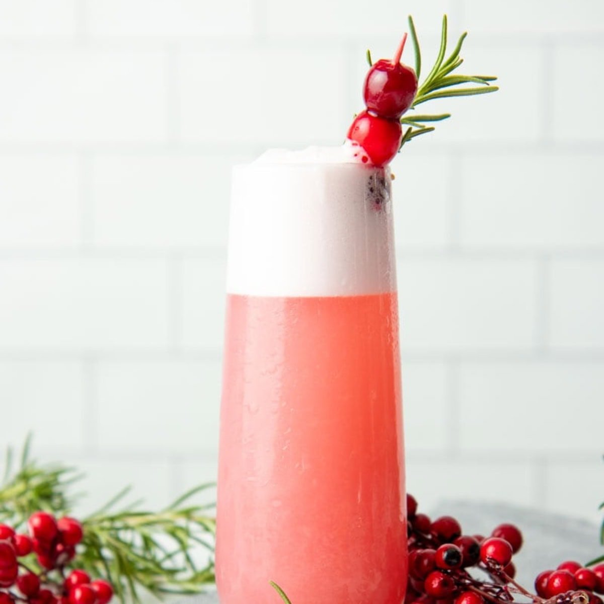 A cranberry gin fizz in a tall, narrow glass.