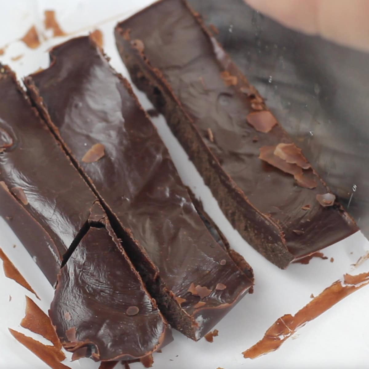A batch of fudge gets cut into pieces.
