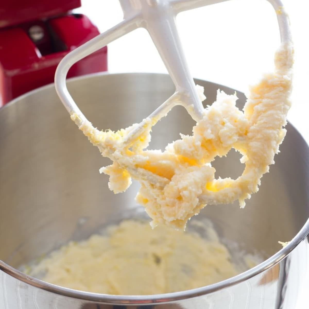 The paddle of a stand mixer, covered in lemon cookie dough.