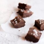 Squares of vegan fudge sprinkled with shredded coconut.