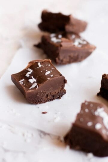 Squares of vegan fudge sprinkled with shredded coconut.