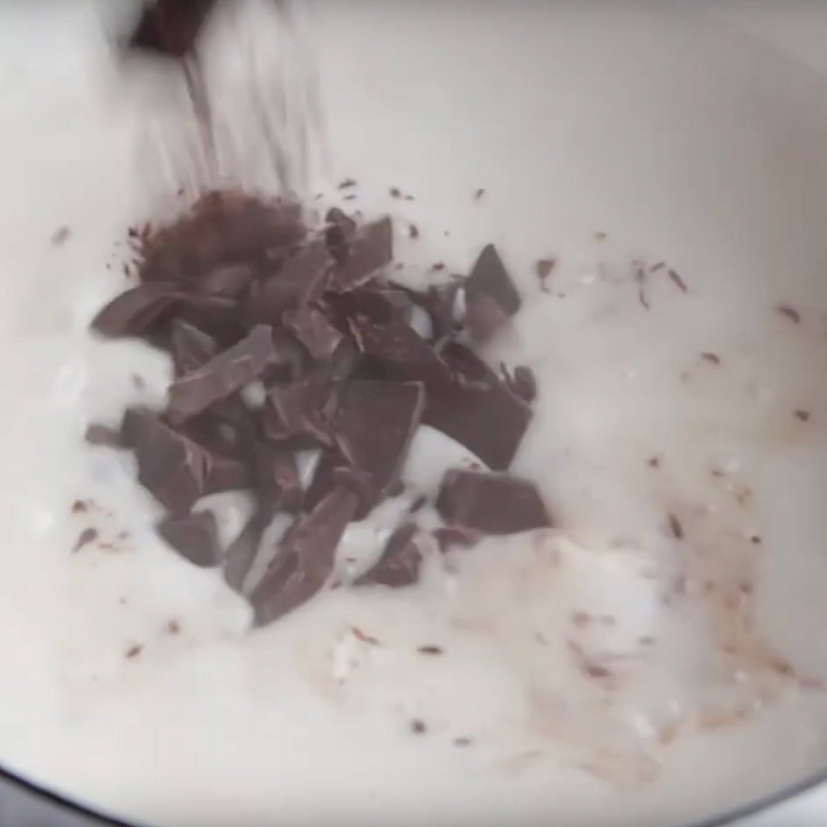 Dark chocolate gets added to hot milk.