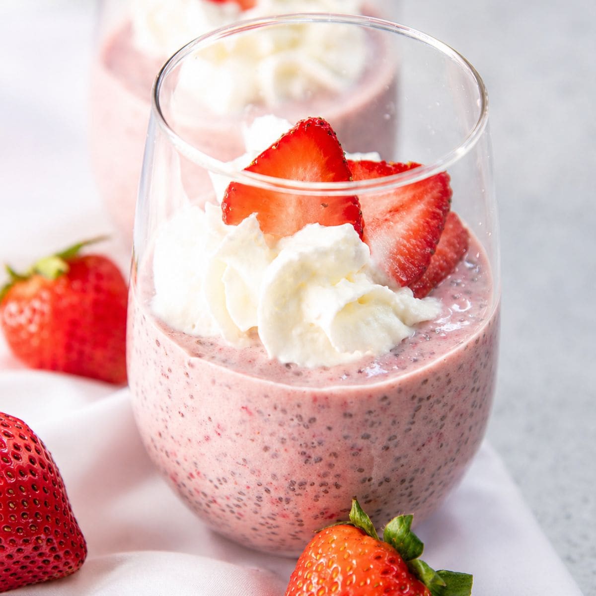 Strawberry chia seed pudding in a win glass on a counter