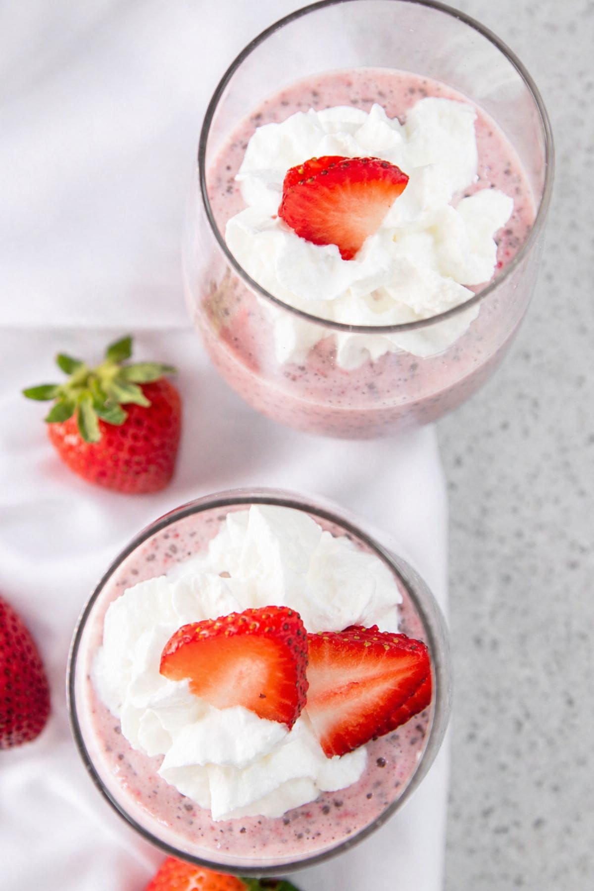 Two glasses of strawberry chia seed putting sit on a countertop