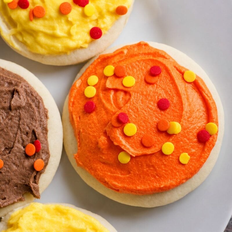 Lofthouse sugar cookies with fall colored icing on a white plate